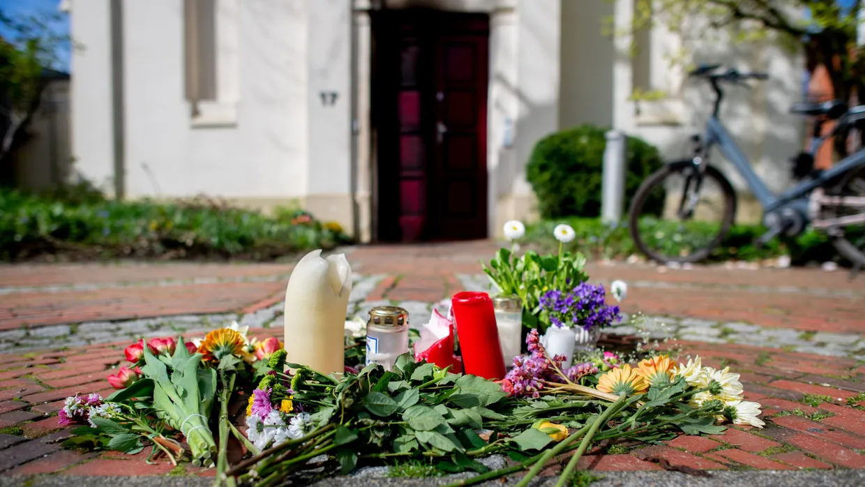 Blumen und Kerzen liegen vor der Synagoge im Stadtzentrum Oldenburgs