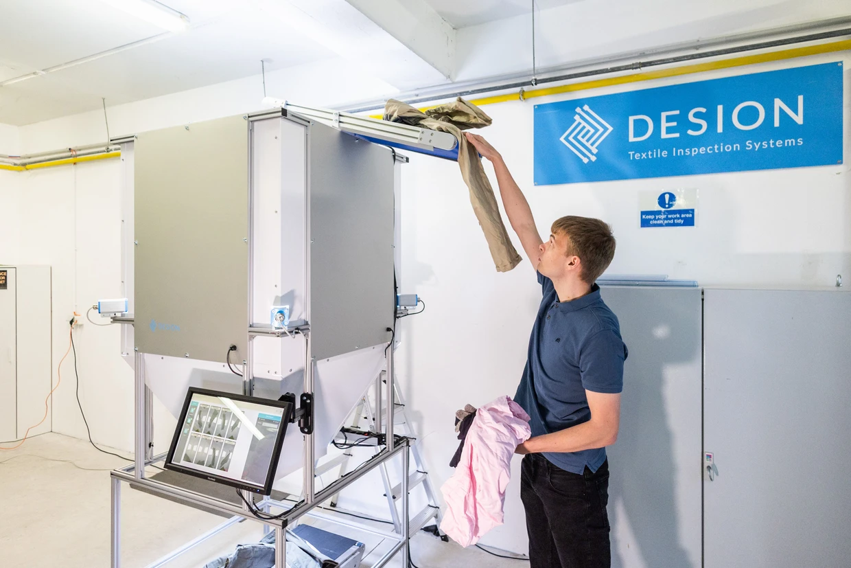 Bei der Desion GmbH präsentiert ein Mitarbeiter das Inspektionssystem für Altkleider.