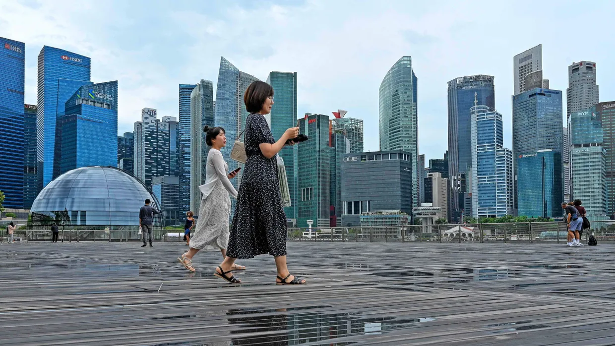 Unter Beobachtung: Passanten vor der Skyline Singapurs