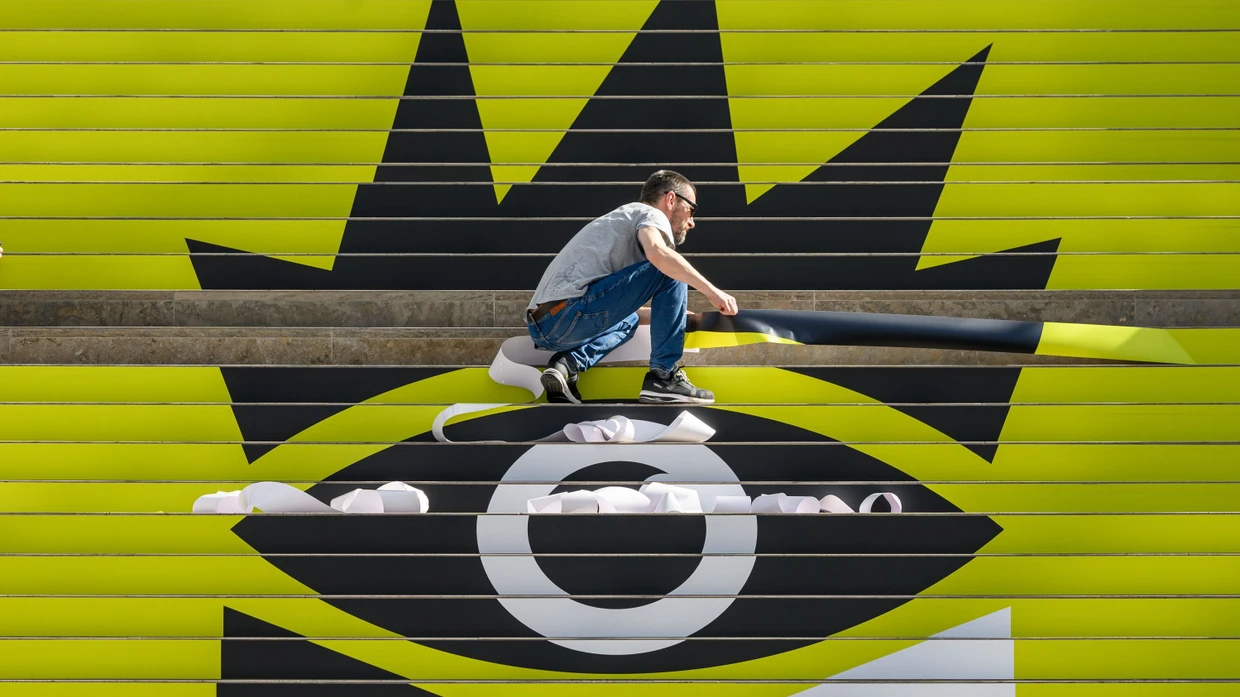 Da könnte zu Beginn schon etwas ins Auge gehen: Auf einem Treppenaufgang des Leipziger Messegeländes wird das Signet der Buchmesse aufgeklebt.