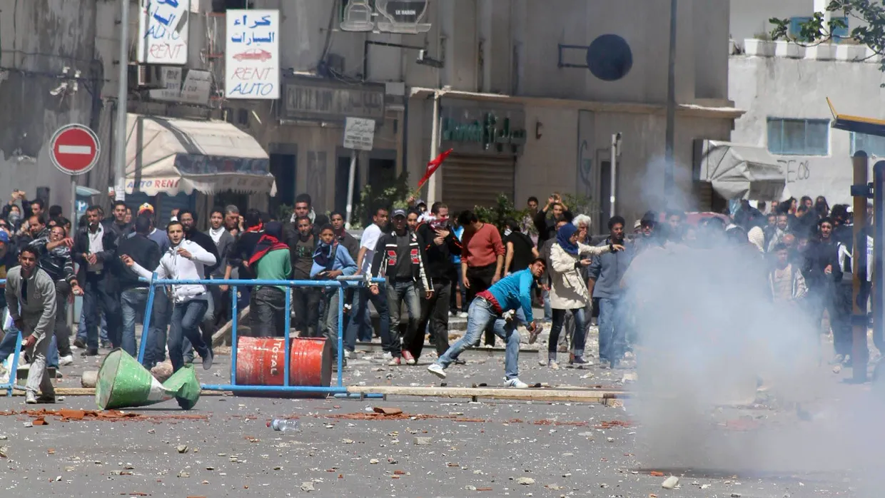 Wutausbruch: Jugendliche werfen Steine auf die Polizei. Diese löste am Montag eine Demonstration in Tunis mit Gewalt auf