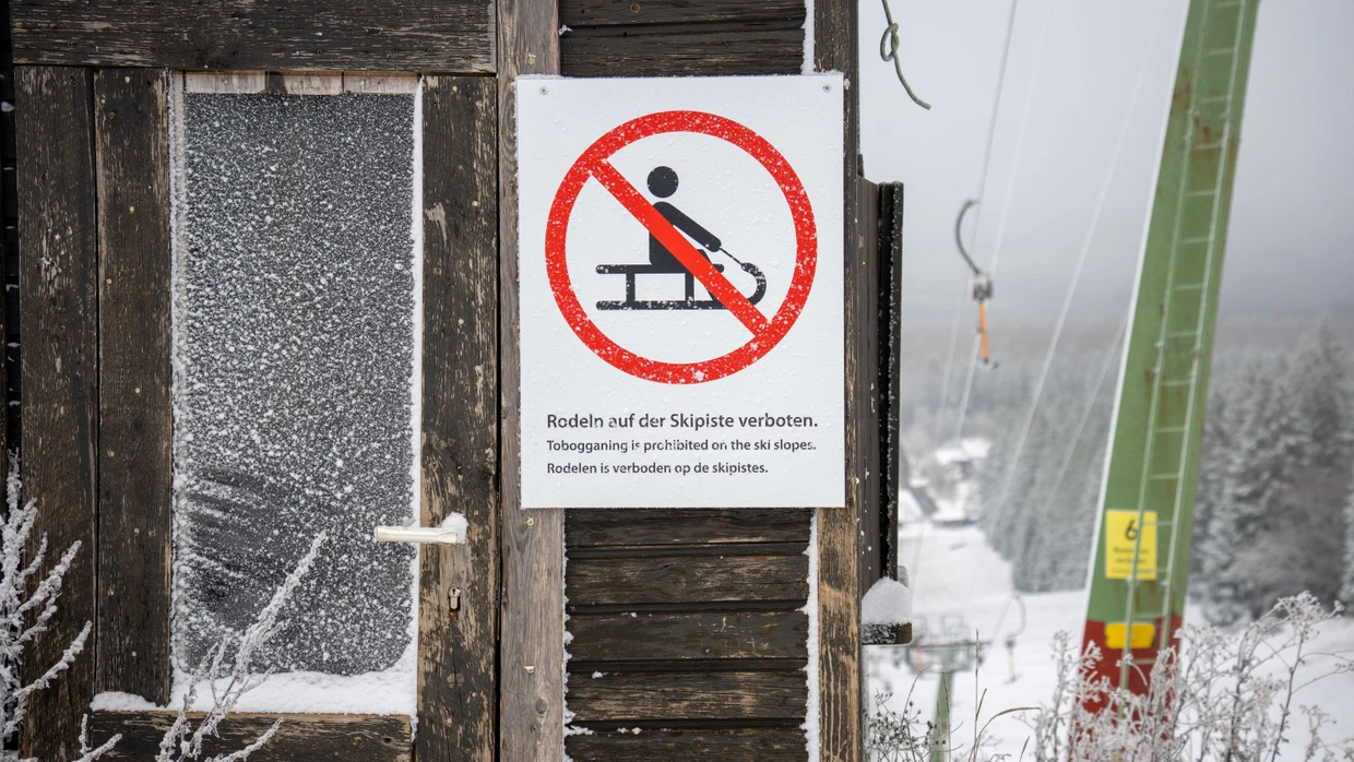 Ein Schild verbietet das Rodeln auf der Skipiste auf dem Erbeskopf in Deuselbach in Rheinland-Pflaz. Der Skilift ist aber noch nicht in Betrieb, Wintersport zur Zeit gar nicht möglich.