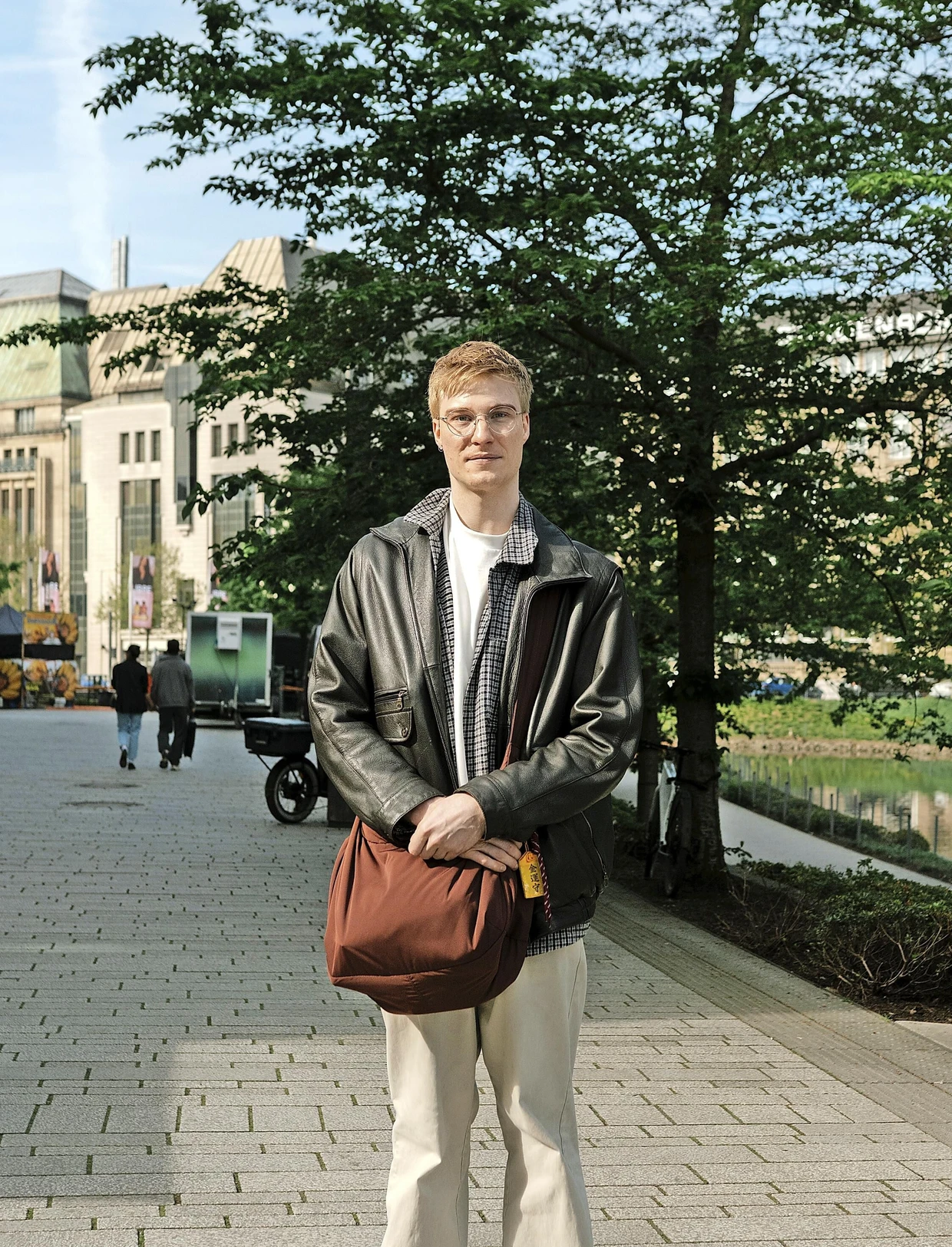 Sven, 29 Jahre alt, trägt eine Vintagejacke vom Onkel und eine Tasche von Uniqlo.