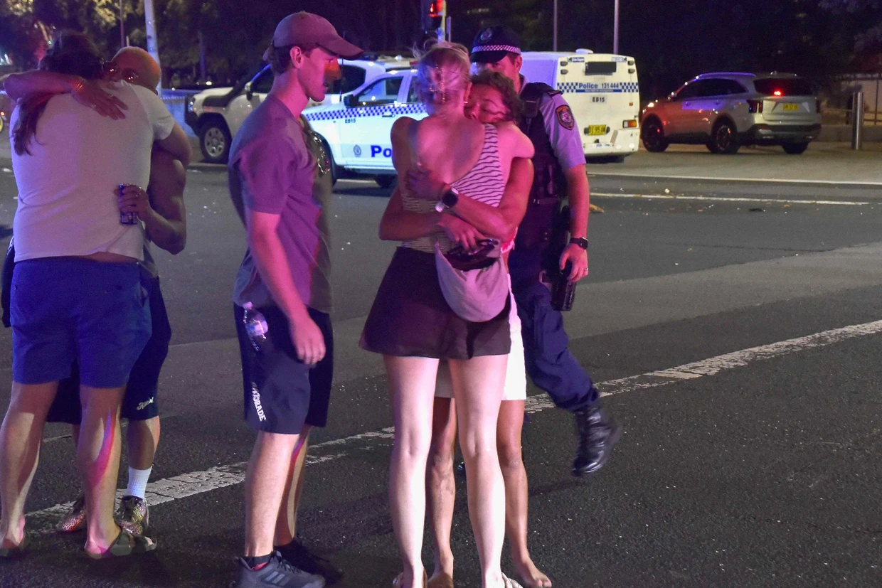 Menschen spenden einander nach dem Anschlag an Bondi Beach in Sydney Trost.
