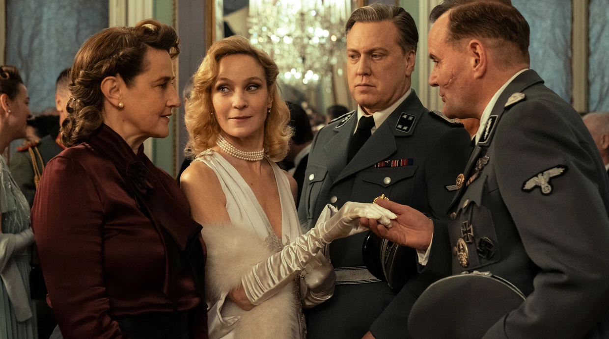 Meckerle (Devid Striesow, r.) täuscht seiner Frau Hilde (Barbara Gassner, l.) vor, die Abendbegleitung von Buback (Nicholas Ofczarek) Marleen Baumann (Jeanette Hain, Mitte) das erste Mal zu treffen und kennenzulernen.