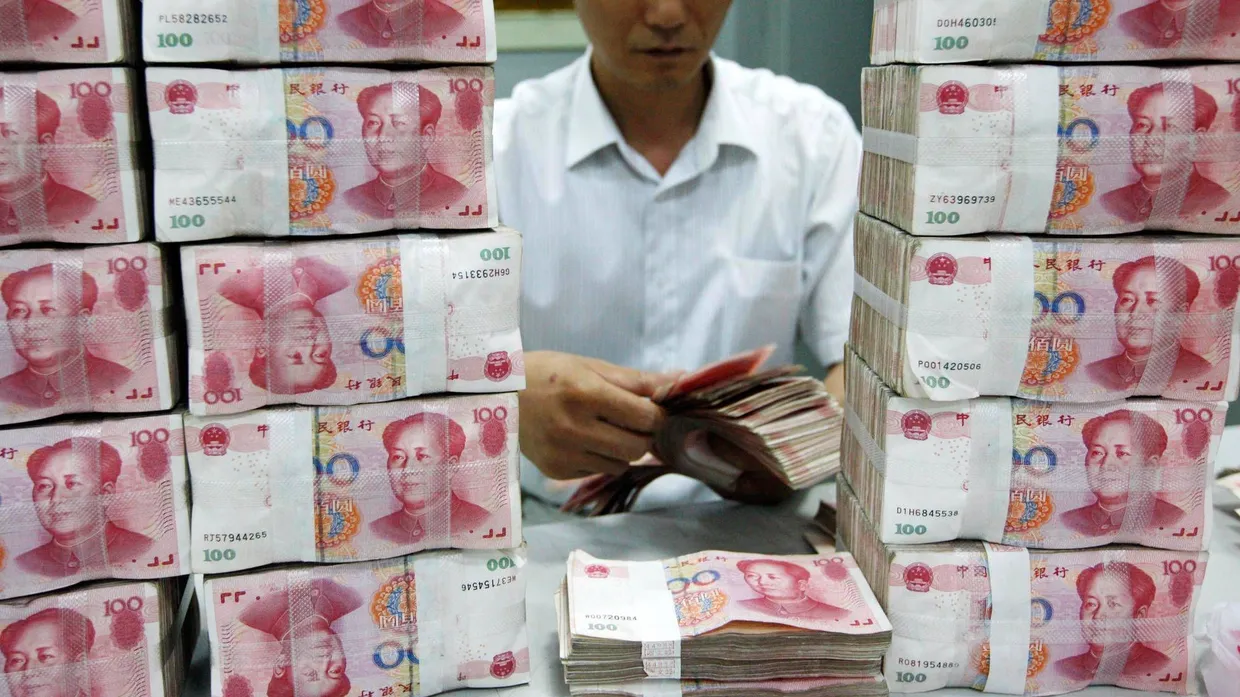 Ein Chinesischer Bankangestellter zählt Geld.