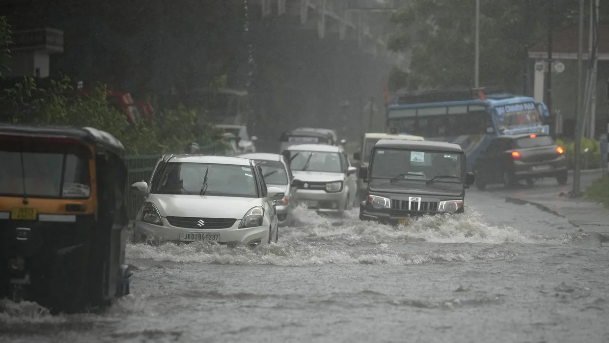 Fahrzeuge fahren durch eine überschwemmte Straße während des starken Monsunregens im indischen Jammu.