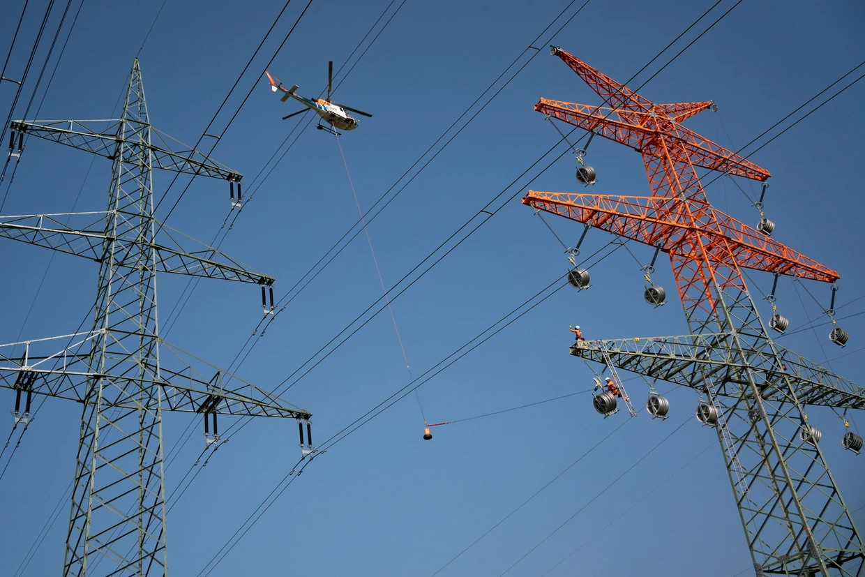 Nervenkitzel: Der Hubschrauberpilot fliegt das Seil den Monteuren in die Hand.