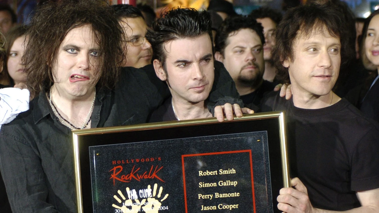 The Cure bei einer Preisverleihung im Jahr 2004 von links nach rechts: Robert Smith, Simon Gallup, Perry Bamonte.