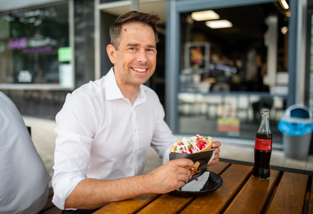 Stadtrat Christoph Troßbach (CDU) isst im Sommer 2024 in der Heilbronner Innenstadt einen Döner.