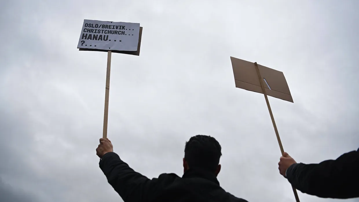 Reihe des Grauens: Ein Teilnehmer des Trauerzugs am Sonntag in Hanau erinnerte an frühere Massenmorde von Rechtsextremen in aller Welt