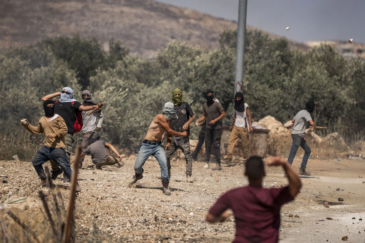 Israelische Siedler werfen in Turmusaya im Westjordanland Steine auf palästinensische Dorfbewohner.