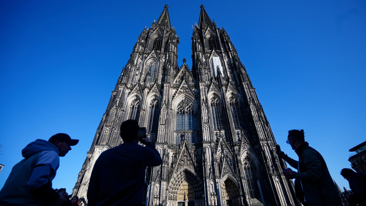 Touristen fotografieren den Kölner Dom.