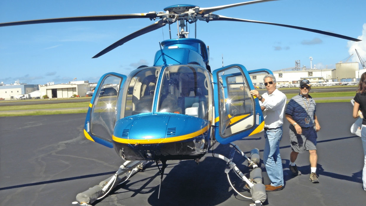 Constantly on the go: Jeffrey Epstein poses in front of a helicopter.