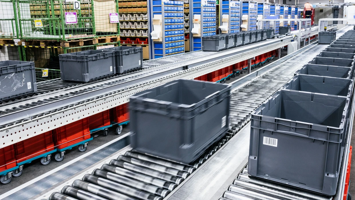 Transportboxen in einem Verteilerzentrum: Was im Warenkorb landet, entscheidet immer öfter der KI-Agent.