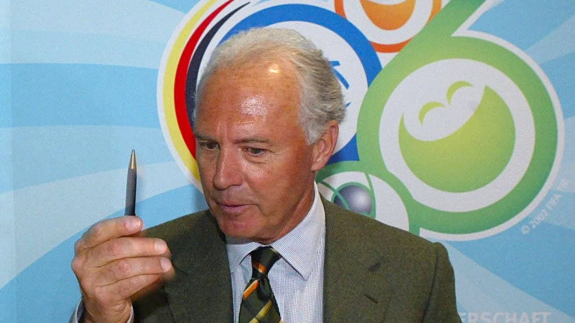 Franz Beckenbauer vor dem Logo der WM 2006 (Bild von 2003)