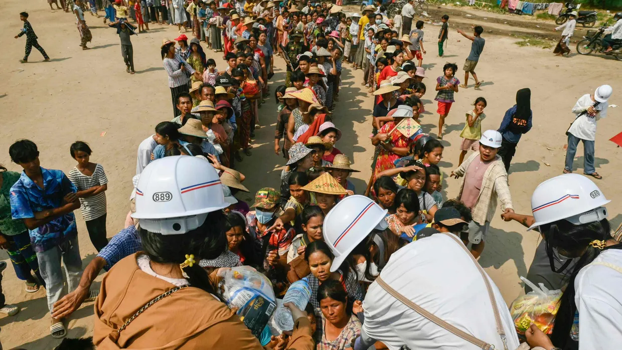 In der Stadt Sagaing nehmen Menschen am Donnerstag Hilfsgüter entgegen.