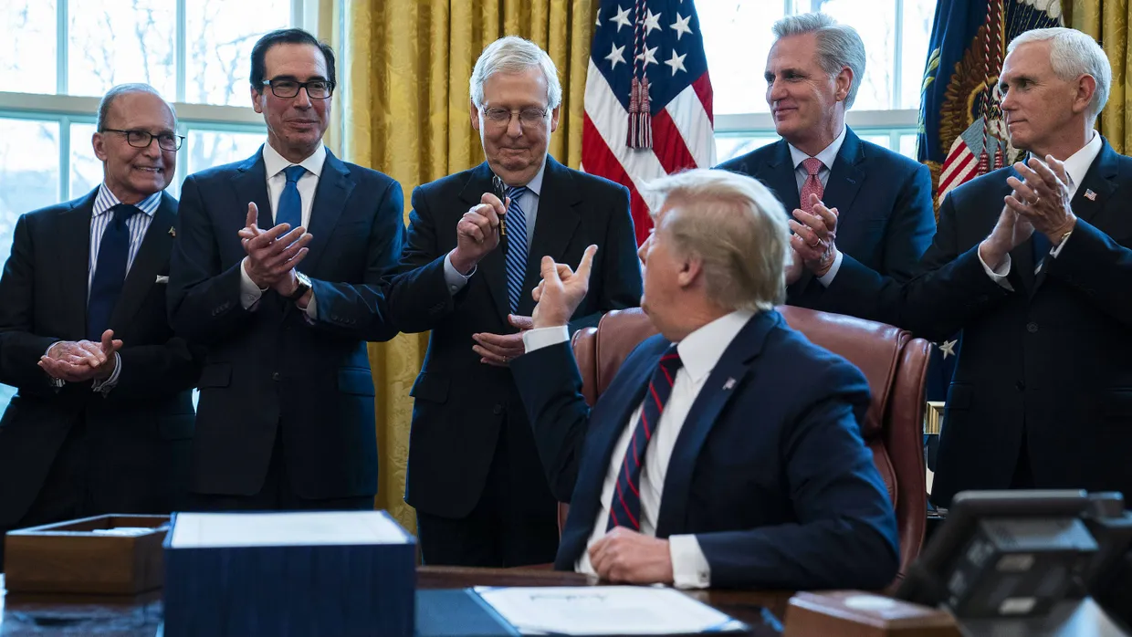 Präsident Donald Trump übergibt dem Mehrheitsführer des Senats, Mitch McConnell (3. vl), Ende März den Stift, mit dem er das erste Corona-Hilfspaket unterzeichnet hat.