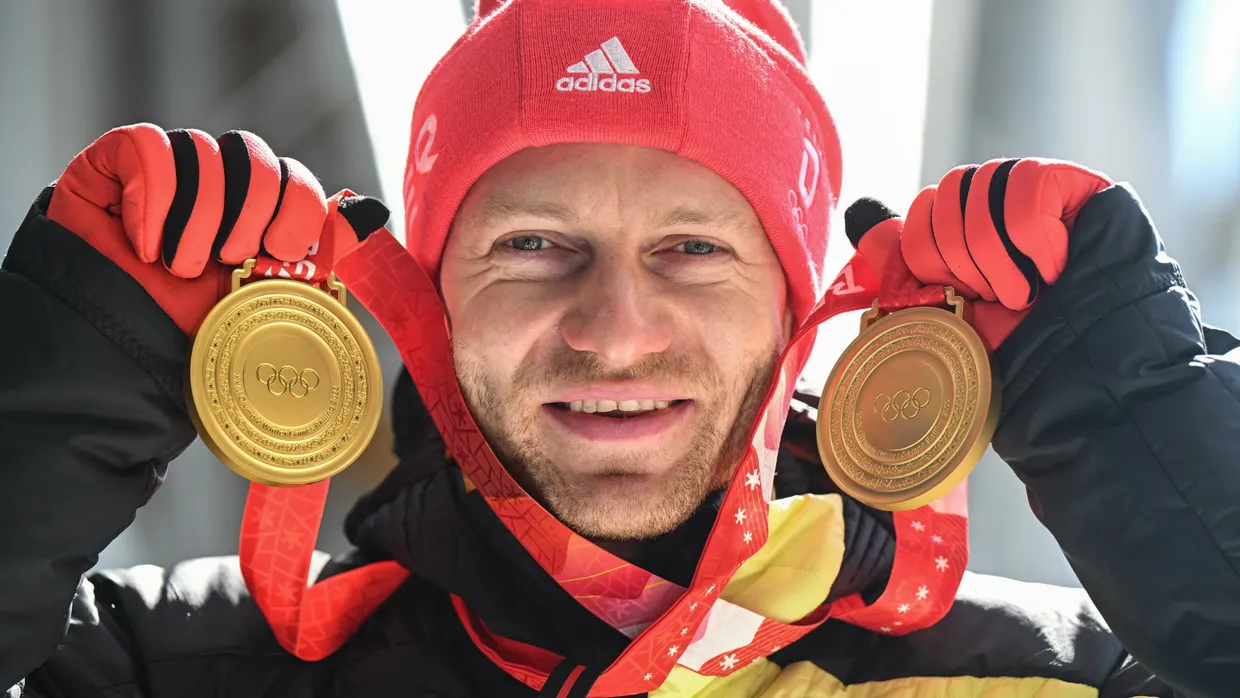 Francesco Friedrich zeigt seine Ausbeute bei den Winterspielen in Peking.