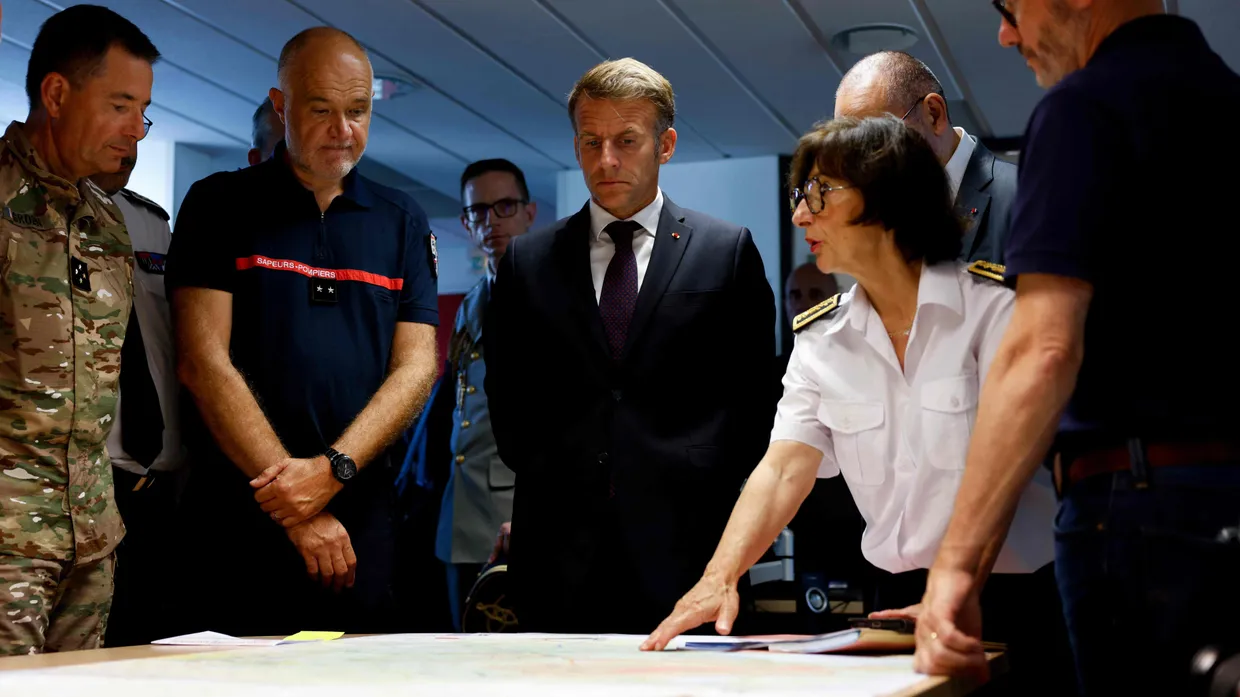 Präsident Emmanuel Macron (Mitte) lässt sich von Sophie Brocas (rechts), Präfektin der Gironde, am 27. Juli die Lage im Waldbrandgebiet erläutern.