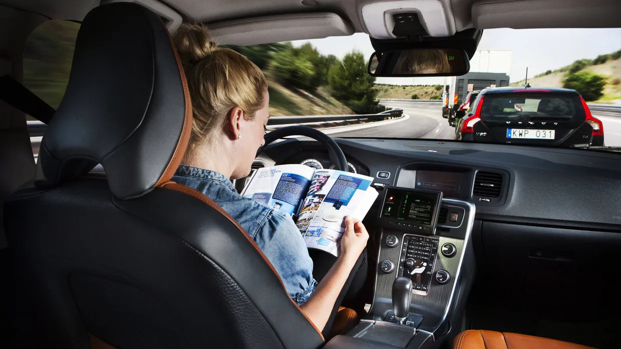 Bald ganz normal in Deutschland? Eine Autofahrerin liest während der Fahrt am Steuer ein Magazin.