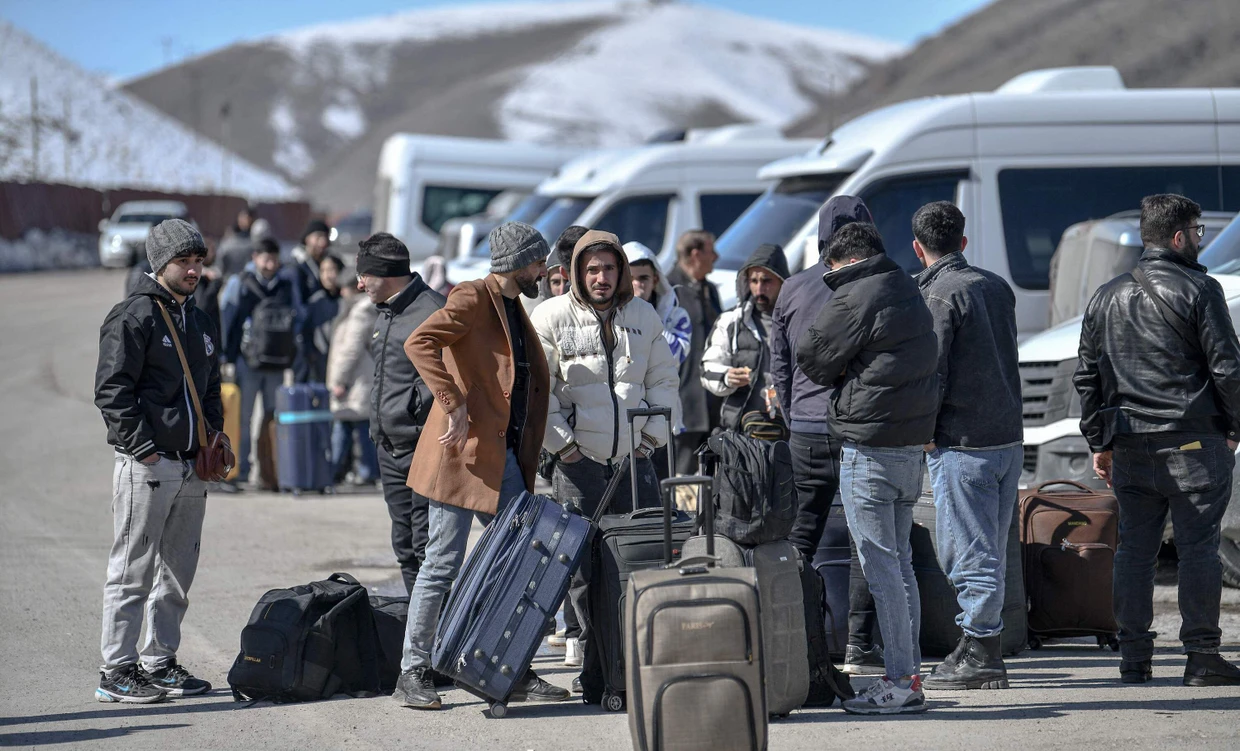 Warten auf die Weiterfahrt: Iraner stehen vor Kleinbussen, nachdem sie die Grenze am Übergang Kapıköy passiert haben