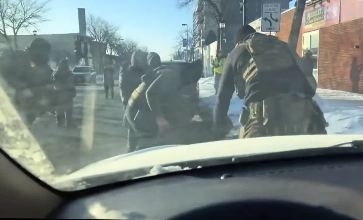 Imagen del vídeo tomada desde el interior de un coche: los agentes se inclinan sobre una persona que yacía en el suelo, se cree que es Alex Pretti.