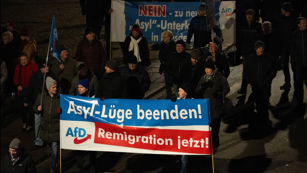 Teilnehmer einer Demonstration mit einem AfD-Plakat im Dezember 2023 in Dresden