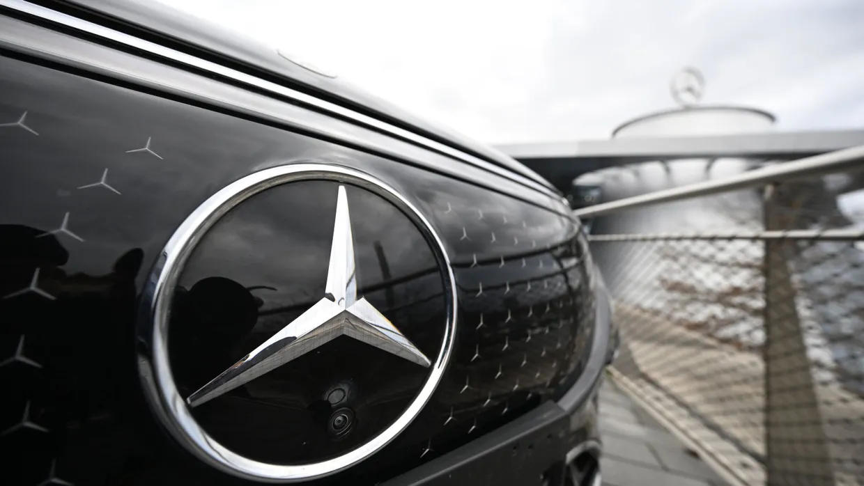 Das Logo der Automarke Mercedes-Benz ist an der Front eines Mercedes-Benz Fahrzeugs angebracht.