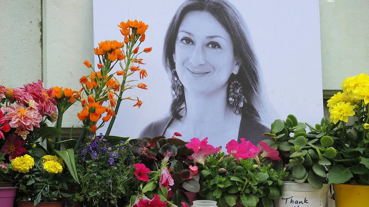 Kerzen und Blumen stehen 2018 im Gedenken vor einem Foto der ermordeten maltesischen Journalistin Daphne Caruana Galizia vor dem Justizpalast.