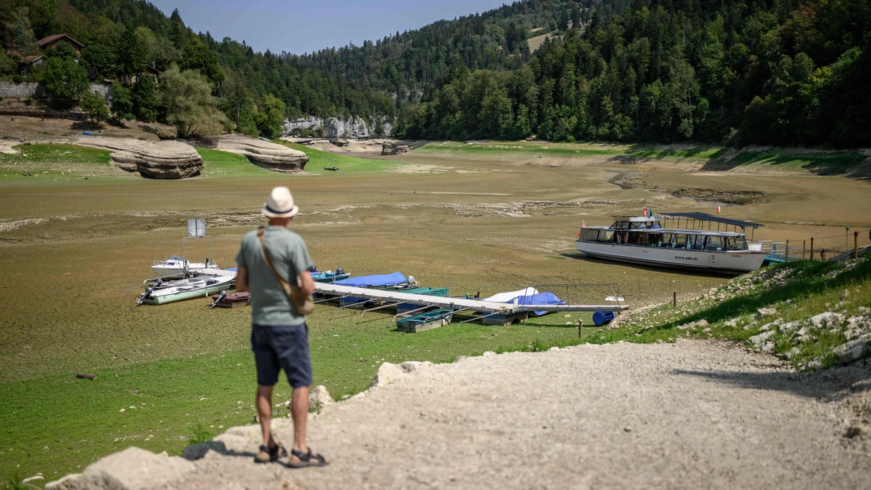 Ein Tourist steht im August am ausgetrockneten Lac des Brenets an der französisch-schweizerischen Grenze.