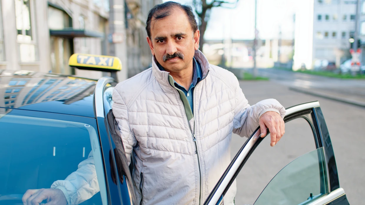 Taxifahrer Muhammad Afzal steht mit seinem Taxi an der Stelle, wo er den Täter bei seiner Amokfahrt durch die Mannheimer Innenstadt stoppte.