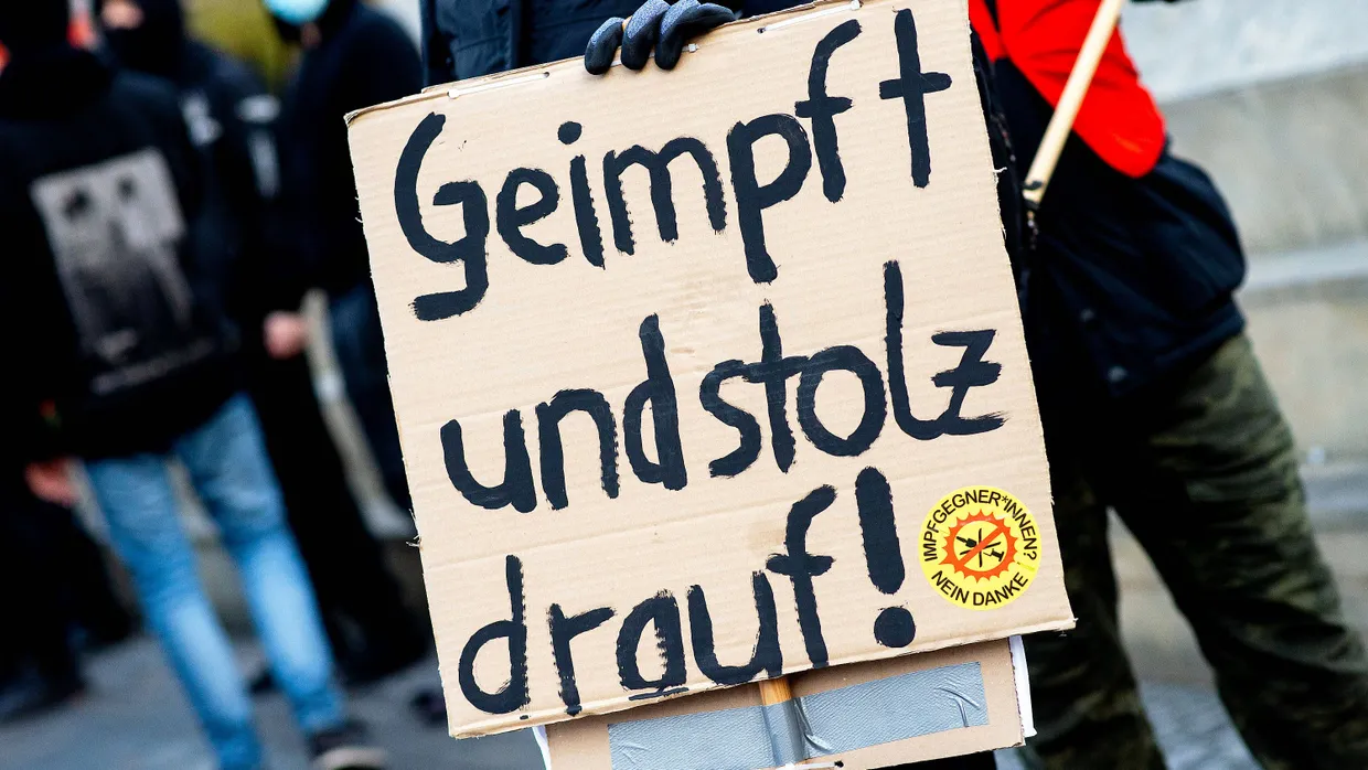 Ein Teilnehmer einer Gegendemonstration steht mit einem Papp-Schild mit der Aufschrift „Geimpft und stolz drauf“ und dem Aufkleber „Impfgegner*innen nein danke“ auf dem Opernplatz in Hannover.