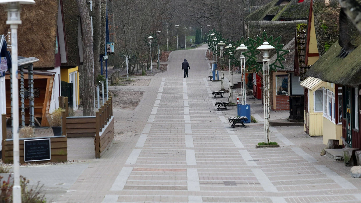 Ein einzelner Spaziergänger ist am Dienstag auf der Promenade vor der Seebrücke des Ostseebades Prerow unterwegs.