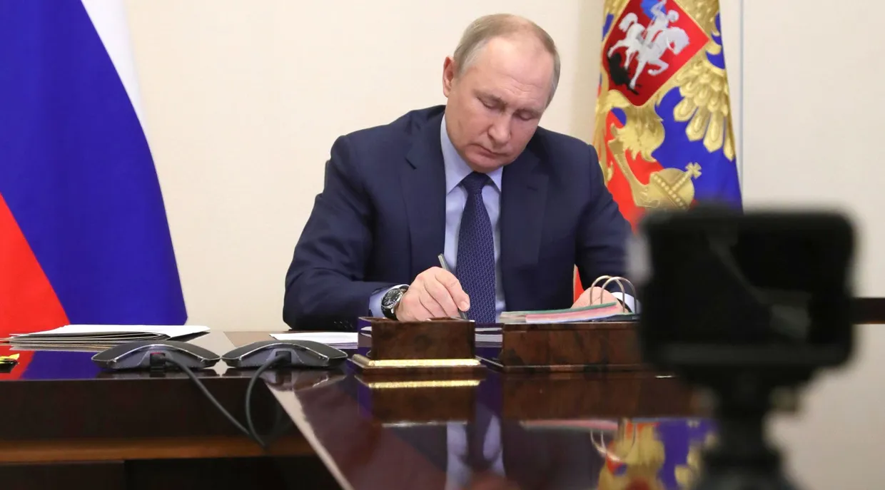 Der russische Präsident Wladimir Putin unterzeichnet am 25. März 2022 im Gästehaus der Regierung in Novo-Ogaryovo ein Dokument.
