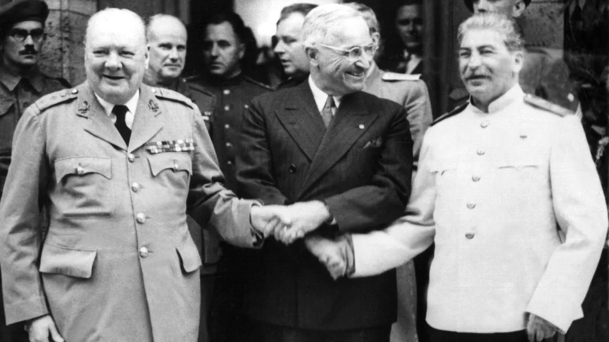 Der britische Premierminister Winston Churchill, der amerikanische Präsident Harry S. Truman und der sowjetische Diktator Josef Stalin reichen sich während der Postdamer Konferenz vor Schloß Cecilienhof die Hände.