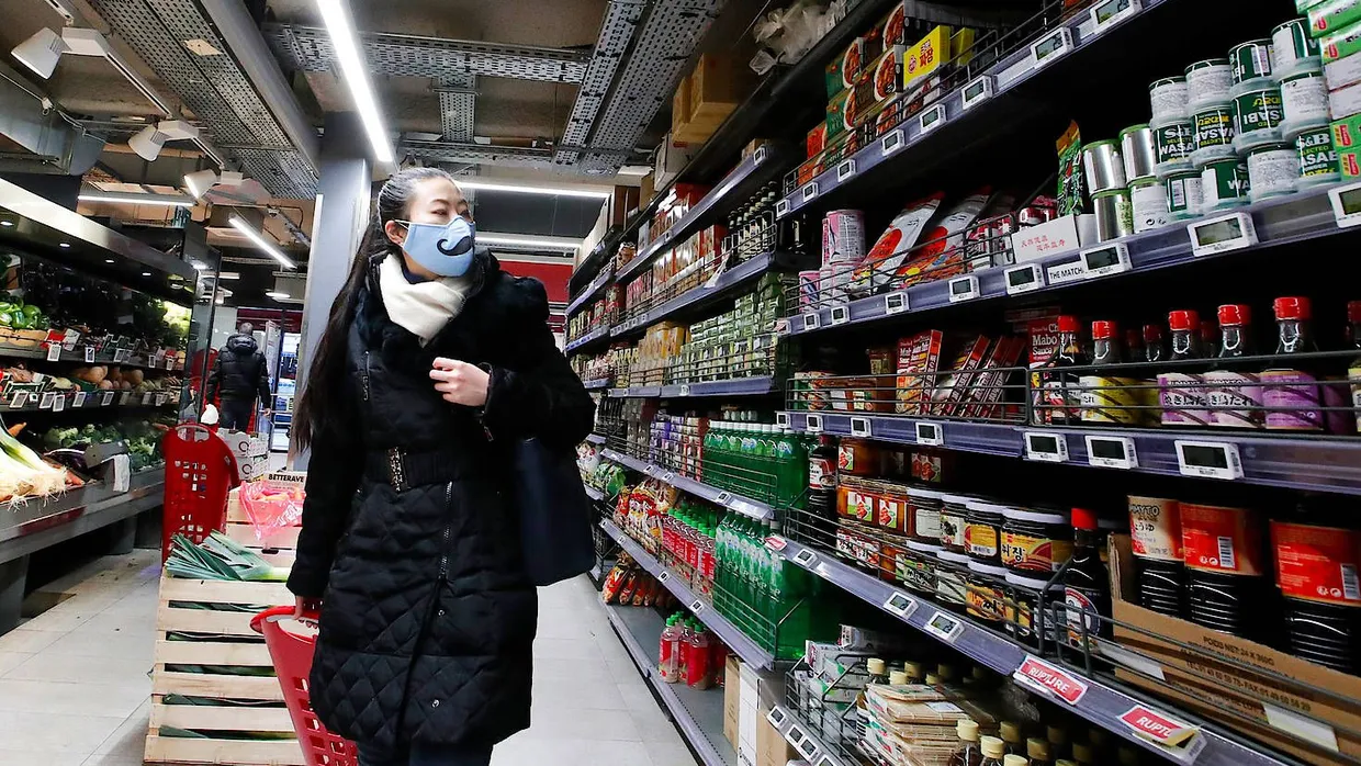 Ist jetzt Pflicht: Eine Kundin kauft mit Mundschutz in einem Supermarkt im 13. Arrondissement in Paris ein.