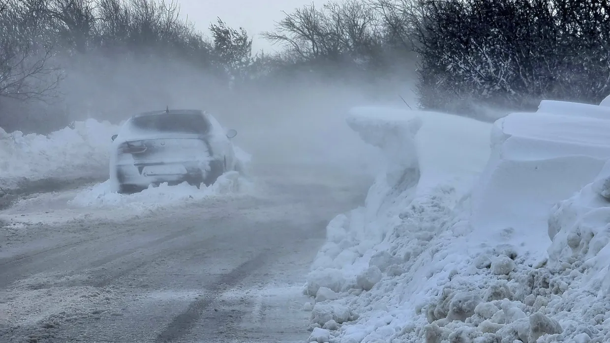 Ein Auto steht auf einer vereisten und schneebedeckten Straße in Dobritsch.
