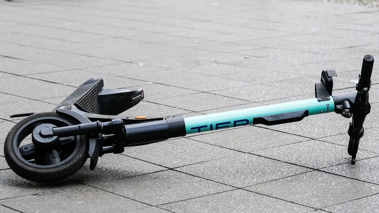 Ein umgekippter E-Scooter auf einem Gehweg (Symbolbild)
