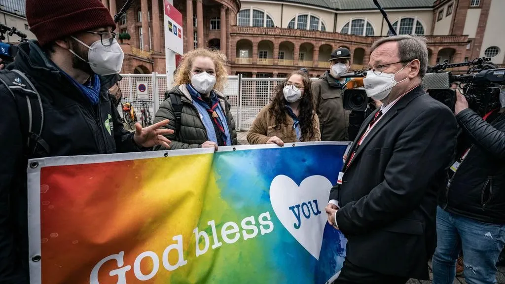 Gelebte Homosexualität soll keine Sünde mehr sein: Reformer in der katholischen Kirche fordern den Segen für homosexuelle Paare ein. Der Vorsitzende der katholischen Deutschen Bischofskonferenz, Georg Bätzing (r.) im Gespräch mit protestierenden jungen Aktivisten.