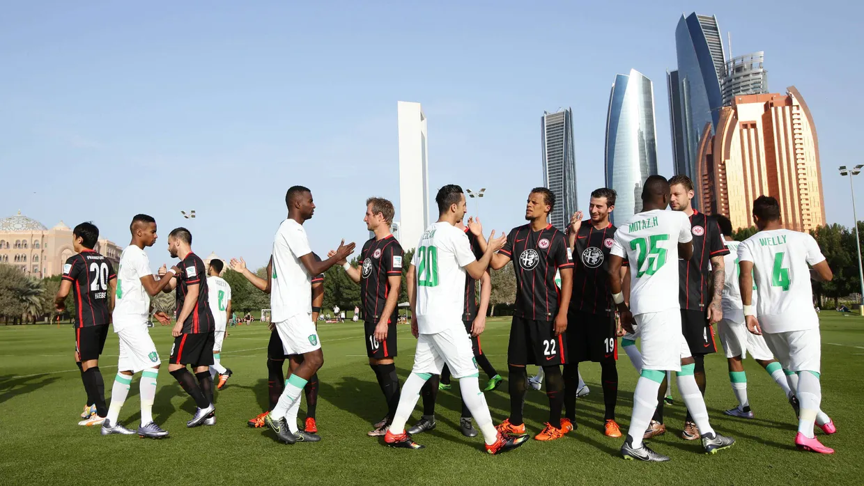 Willkommen zum Test: Saudische und Frankfurter Fußballspieler vor den Wolkenkratzern von Abu Dhabi.
