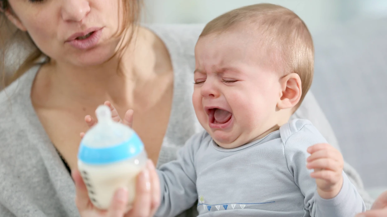 Irgendetwas stimmt nicht mit der Milch: Weinendes Baby mit Fläschchen