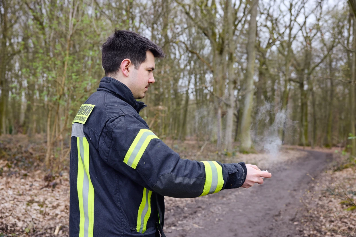 Feuerwehrmann Marlin Prauss nutzt Spray, um sich die Windrichtung anzeigen zu lassen.