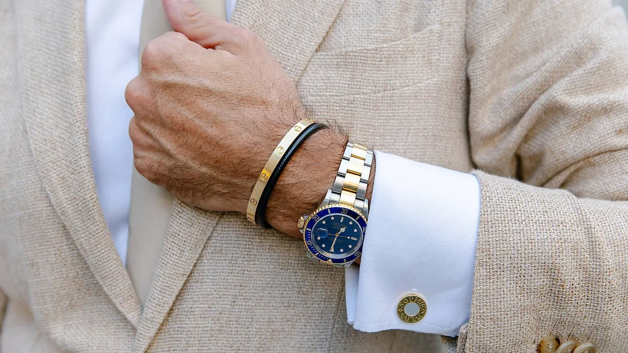 Sichtbarer Wohlstand: Ein Mann trägt eine teure Armbanduhr und Goldschmuck.