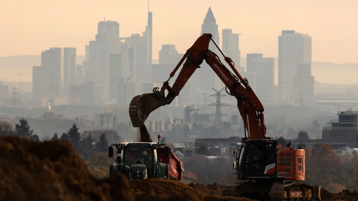 Bagger arbeiten auf einer Baustelle vor der Frankfurter Skyline.