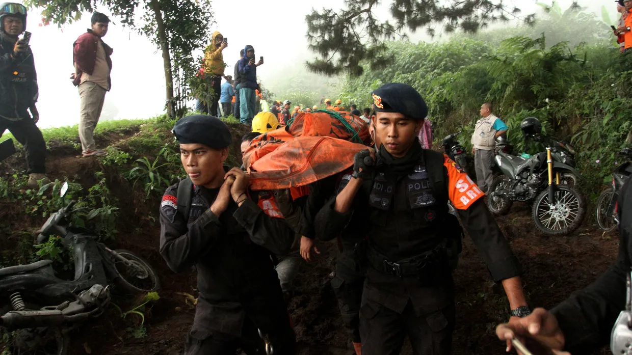 Indonesische Polizisten tragen die Leiche eines Opfers des Vulkanausbruchs.