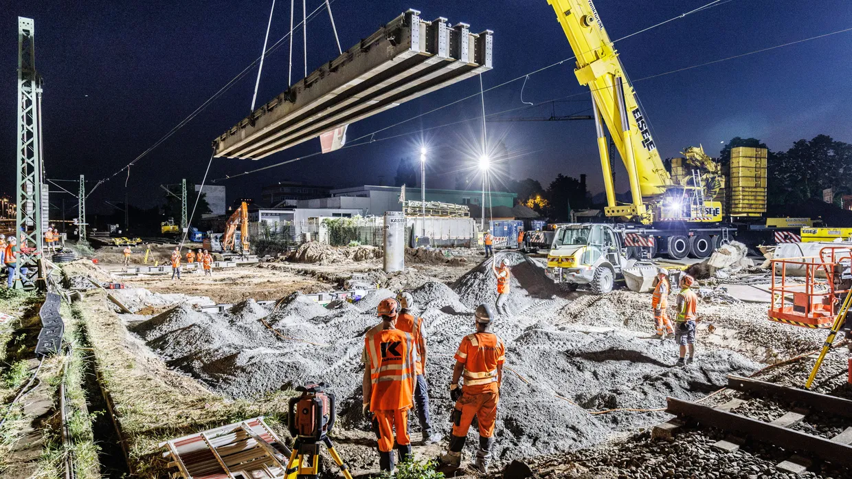 Am Haken: 58 Tonnen wiegt die Hilfsbrücke, die der Kran an ihre Position schweben lässt. Drei Jahre lang rollen darüber die Züge, während darunter gegraben wird.