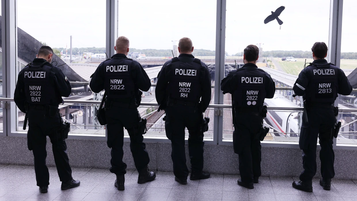 Einsatzkräfte der Polizei stehen über dem Bahnhof des Flughafens Düsseldorf.