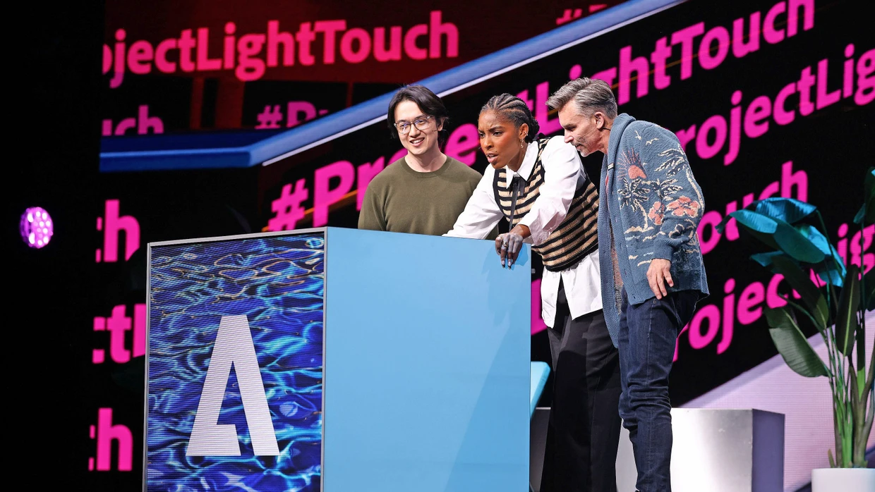 Adobe is confident about the fiscal year: two employees present new Adobe software together with actress Jessica Williams