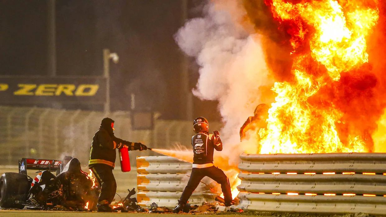 Flucht aus den Flammen: Haas-Pilot Romain Grosjean (rechts im Feuer) hat sich aus dem Cockpit befreit und klettert über die Leitplanken.